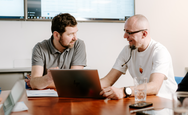 Dva ředitelé společnosti LinuxBox.cz při pracovní konzultaci nad notebookem a plánování digitálních řešení.